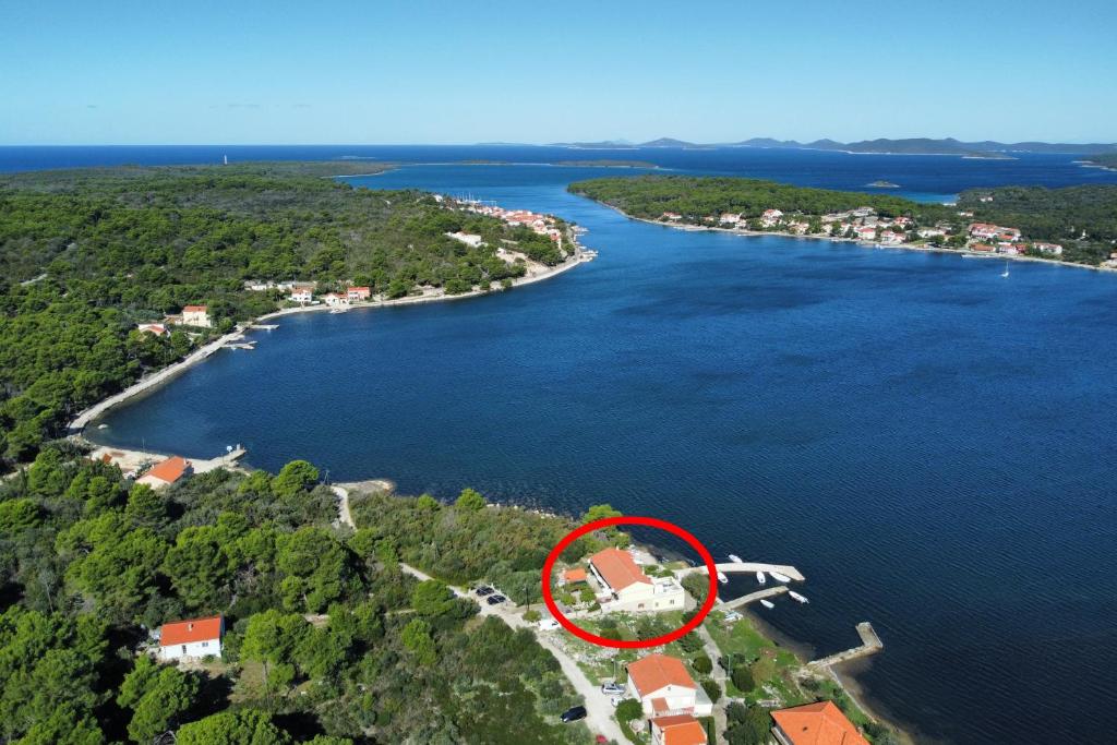 an island with a house in the middle of a lake at Apartments by the sea Veli Rat, Dugi otok - 438 in Veli Rat