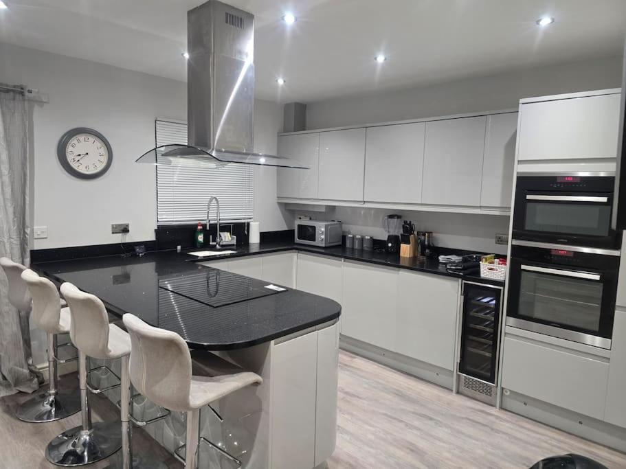 a kitchen with white cabinets and a black counter top at Beautiful AND Cosy -Home Sweet Home in Kent