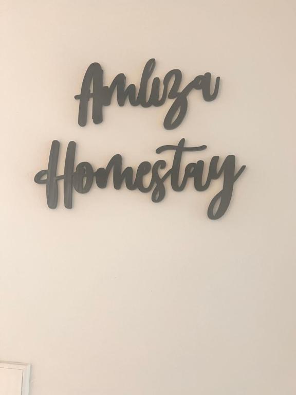 a sign that reads antigua homesteadery hanging on a wall at Amliza homestay in Cyberjaya