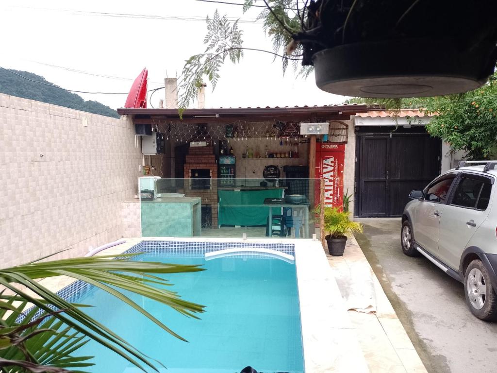 a small blue swimming pool in front of a building at Pousada recanto do sabiá in Mangaratiba