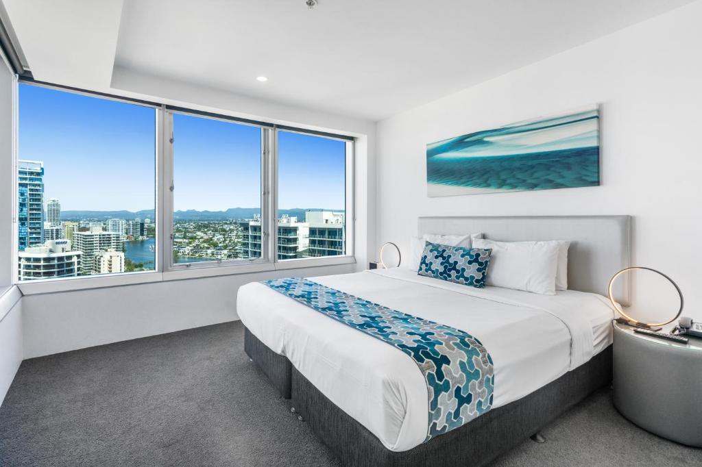 a bedroom with a large bed and large windows at Q1 Resort & Spa - Official in Gold Coast
