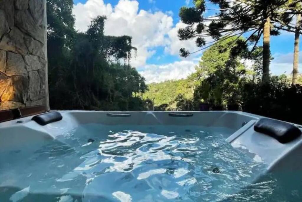 eine Whirlpool-Badewanne mit Bergblick in der Unterkunft Casa Luxo p 12 pessoas ou Suite Premium 4 pessoas com jacuzzi in Campos do Jordão