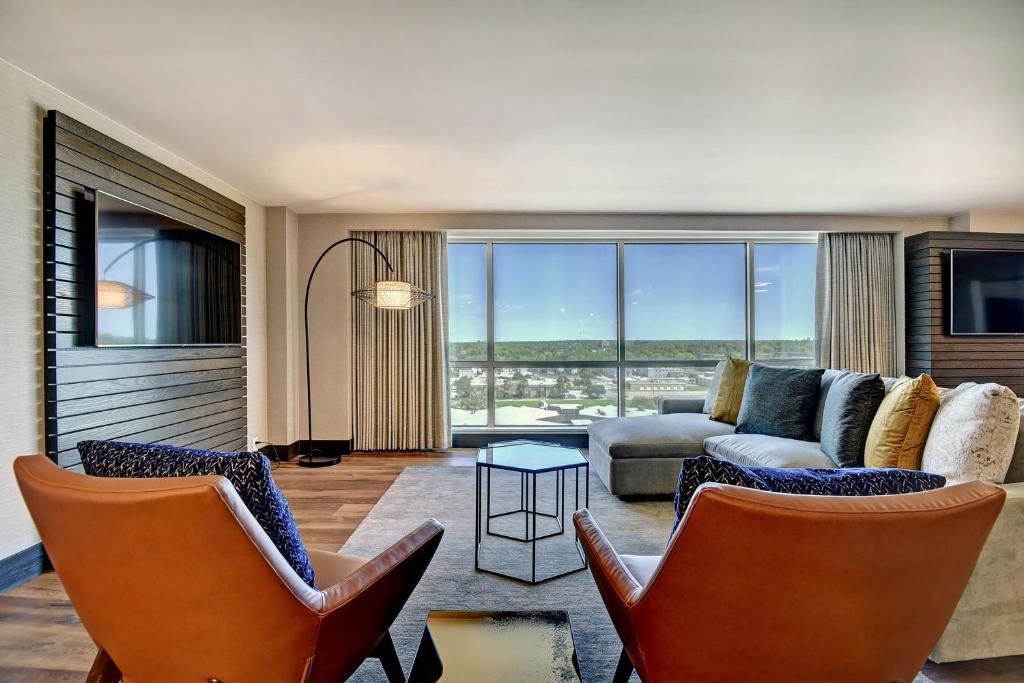 a living room with two chairs and a couch at Tulsa Marriott Southern Hills in Tulsa