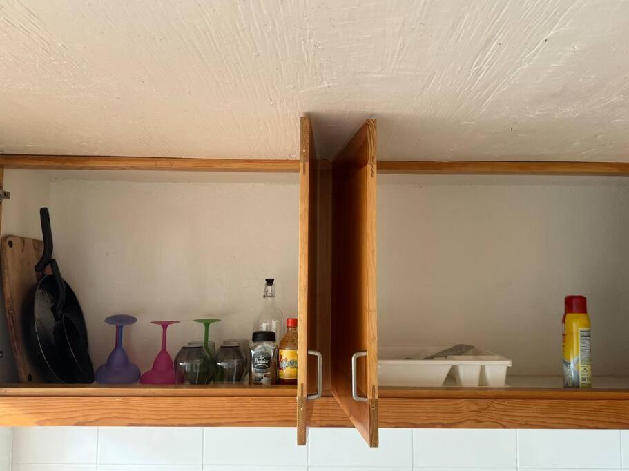 ハラパにあるCasita Bosque Brionesのボトルや花瓶が置かれた木製のキャビネット