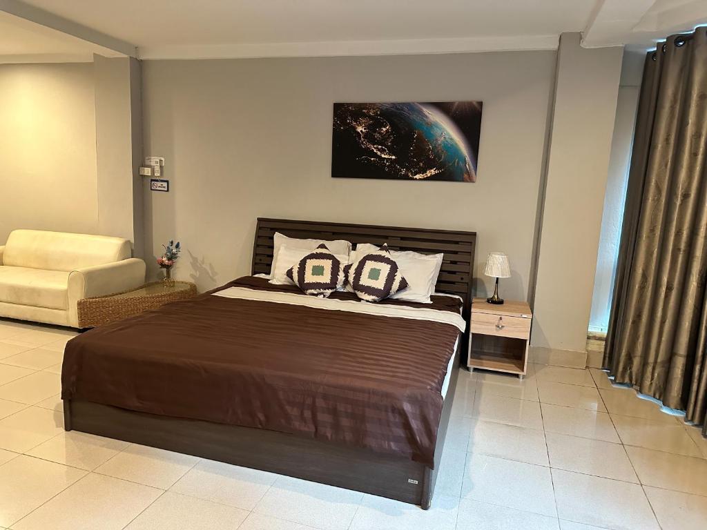 a bedroom with a large bed and a chair at Take time house in Chiang Mai