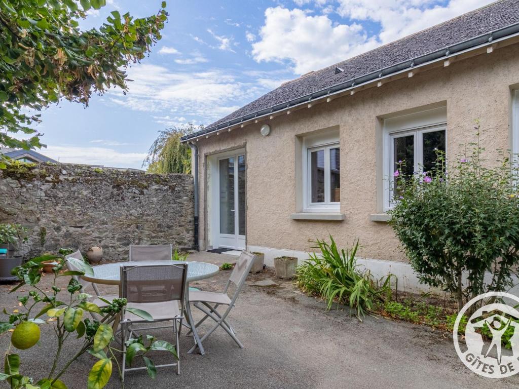 a patio with a table and chairs in front of a house at Maison rénovée avec jardin proche d'Angers - FR-1-622-92 in Rochefort-sur-Loire
