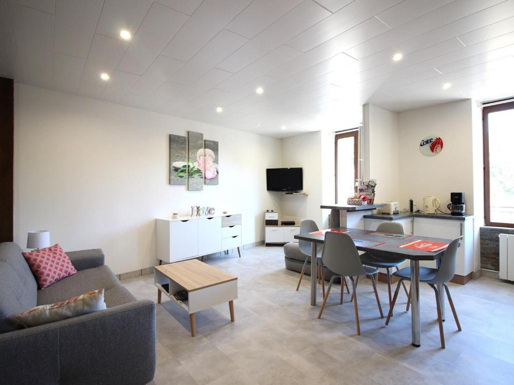 un salon avec un canapé et une table dans l'établissement Charmant T2 avec Wifi, proche thermes à La Bourboule - FR-1-608-272, à La Bourboule