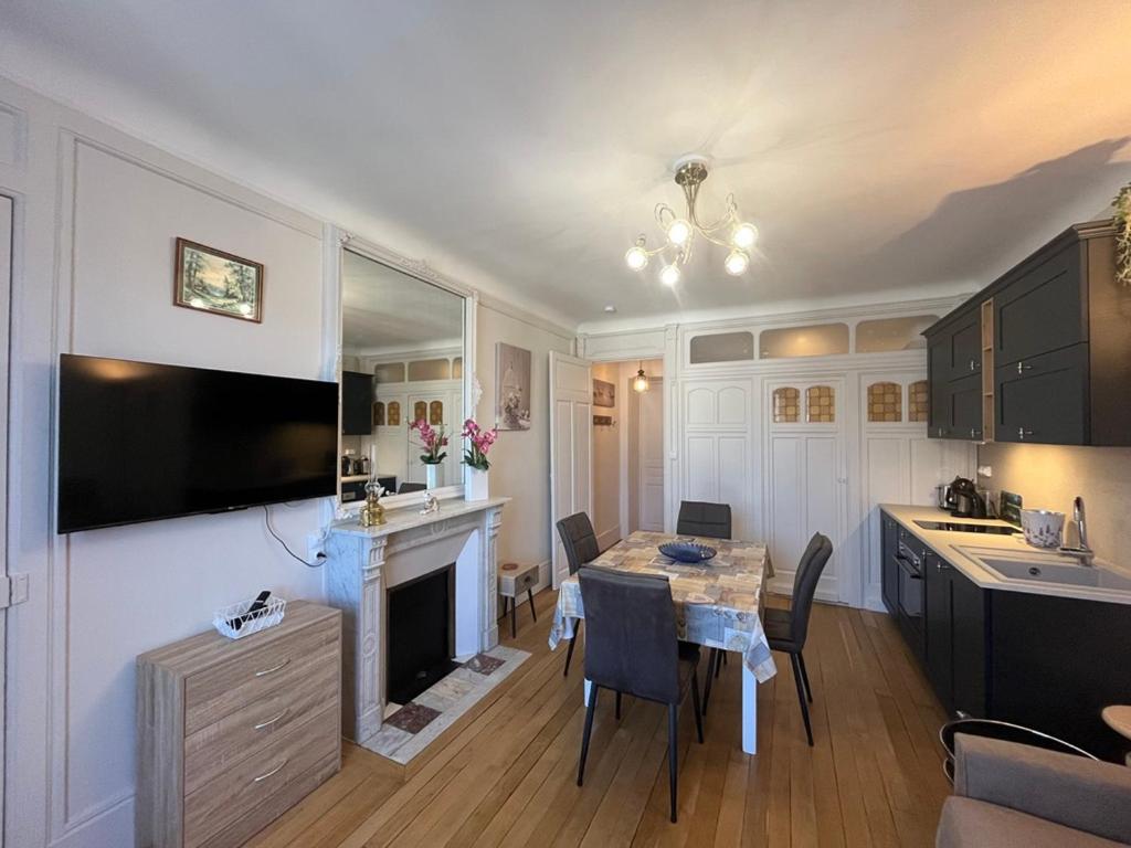 a kitchen and living room with a table and a television at Charmant studio au centre du Mont-Dore, bien équipé, max 2 pers - FR-1-608-273 in Mont-Dore