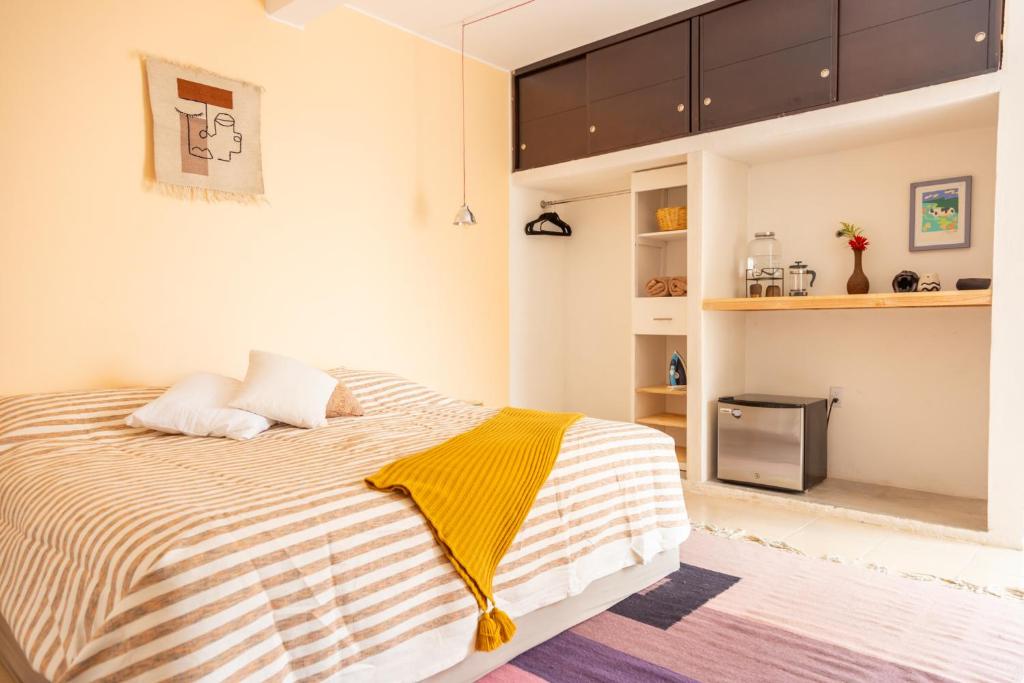 ein Schlafzimmer mit einem Bett mit einer gelben Decke in der Unterkunft Gran casa para amigos a 4 cuadras del Zocalo in Oaxaca de Juárez