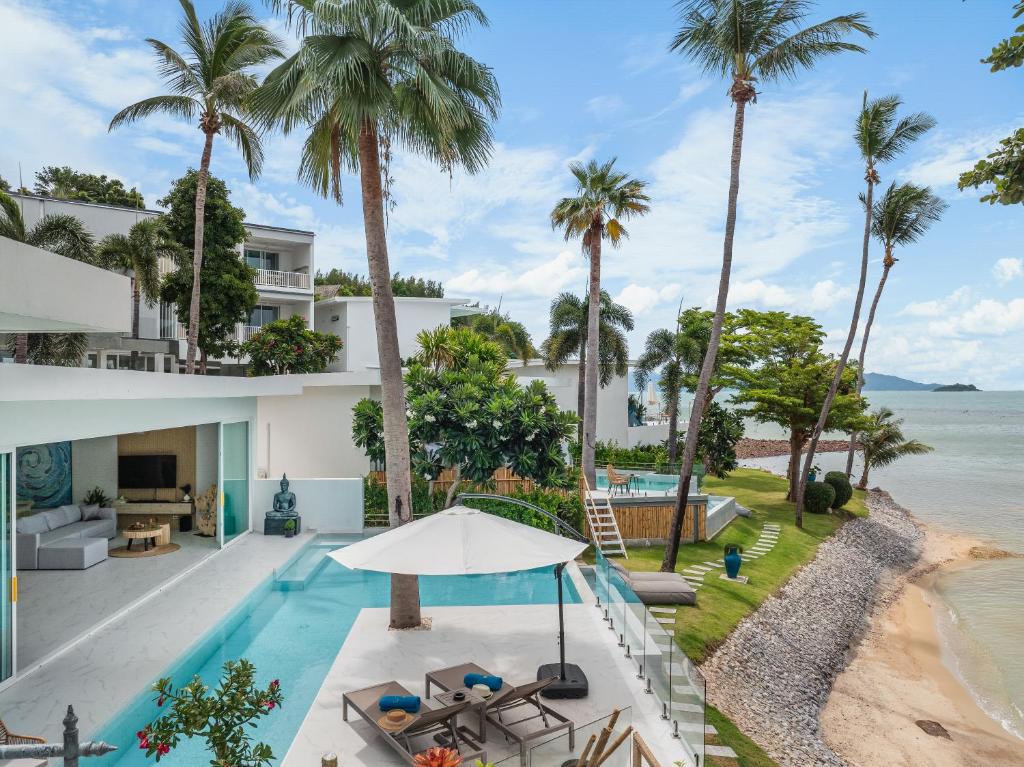 an aerial view of a house with a swimming pool and palm trees at Beachfront Secret Tides Villa Sol in Koh Samui 