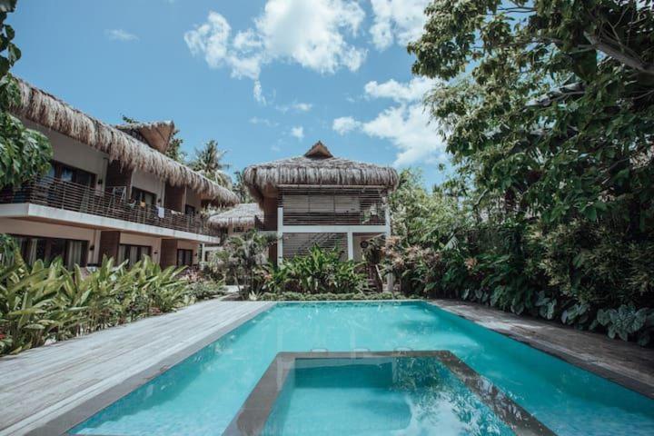 a swimming pool in front of a house at Caracoa Resort in General Luna