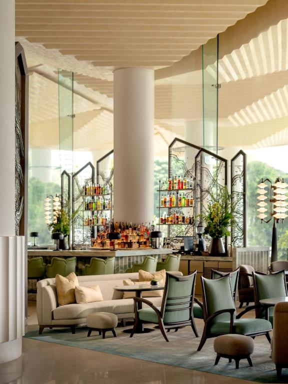 a lobby with a couch and chairs and a bar at Dusit Thani Bangkok in Bangkok
