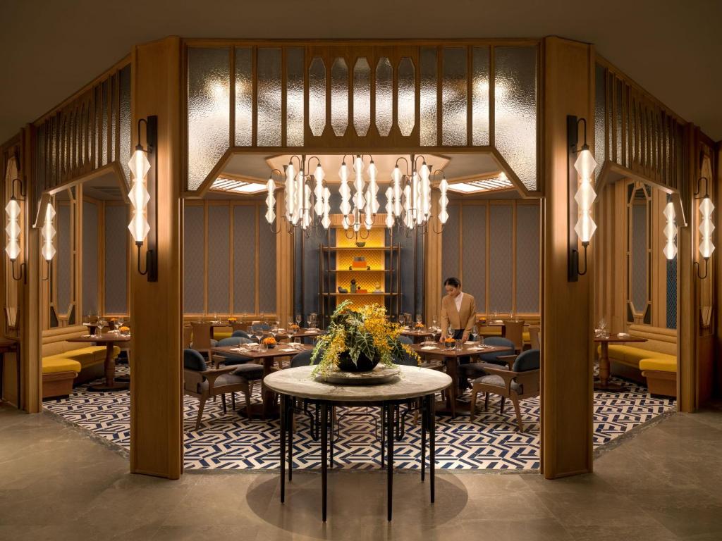 a dining room with tables and a chandelier at Dusit Thani Bangkok in Bangkok