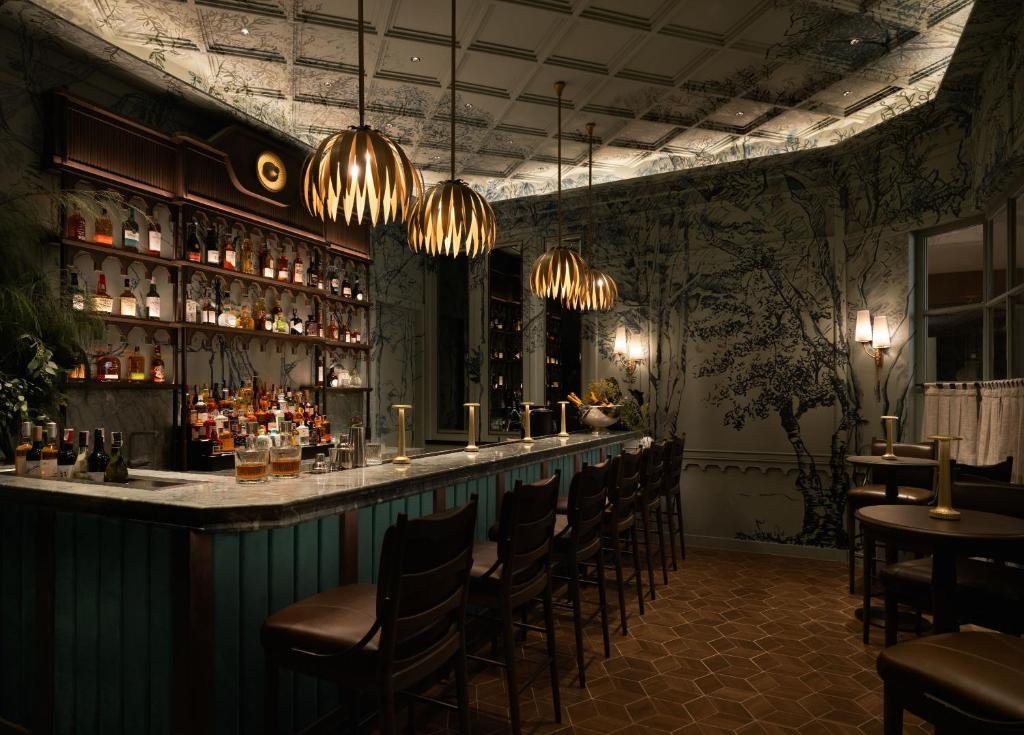 a bar in a restaurant with chairs and lights at Dusit Thani Bangkok in Bangkok