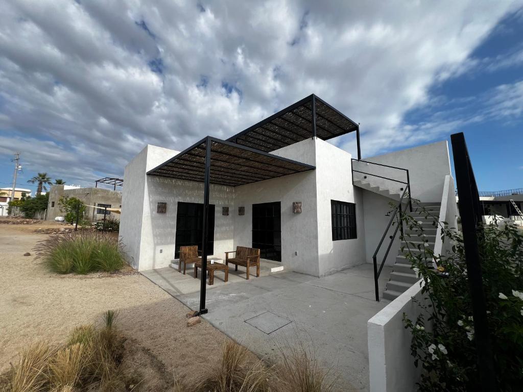a white building with a porch and a bench at Ocean View, Gorgeous Rooftop, AC, Wifi & Peaceful in Todos Santos