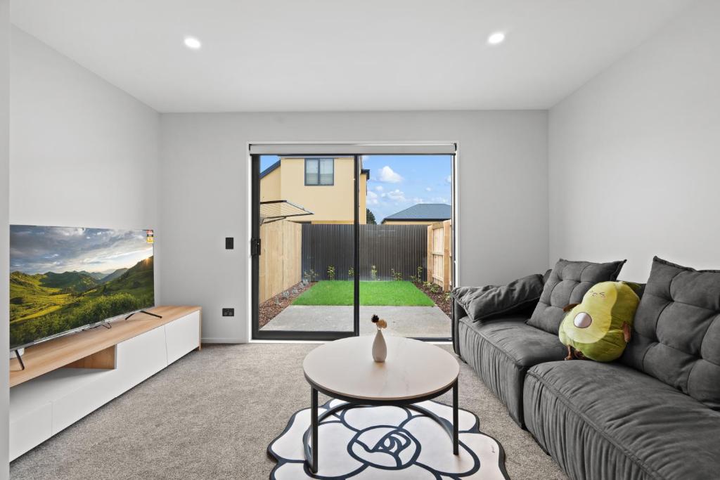 a living room with a couch and a table at Lovely 2BR Home close to Center in Christchurch