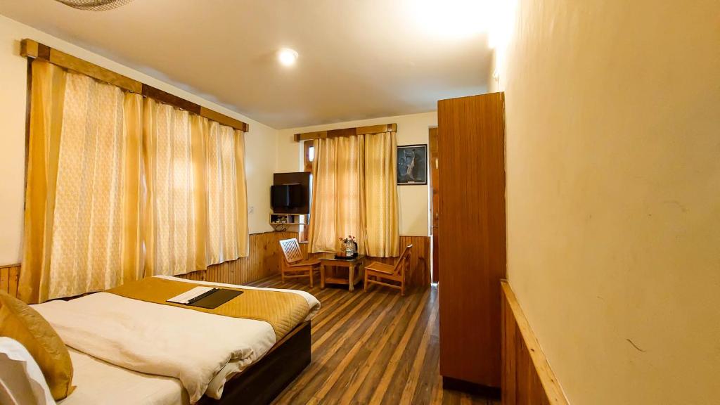 a hotel room with a bed and a desk at Ride At Hills-Nihal Cottage Manali in Manāli