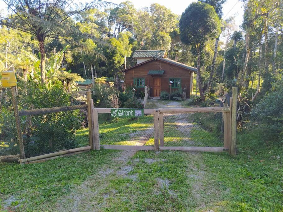 a gate in front of a house with a fence at Cabana aconchegante na natureza in Rancho Queimado