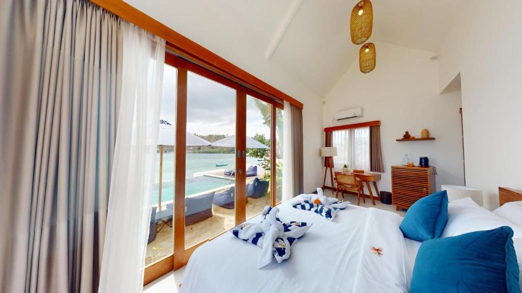 a bedroom with a bed and a view of the ocean at Segara Seaside Resort in Nusa Lembongan