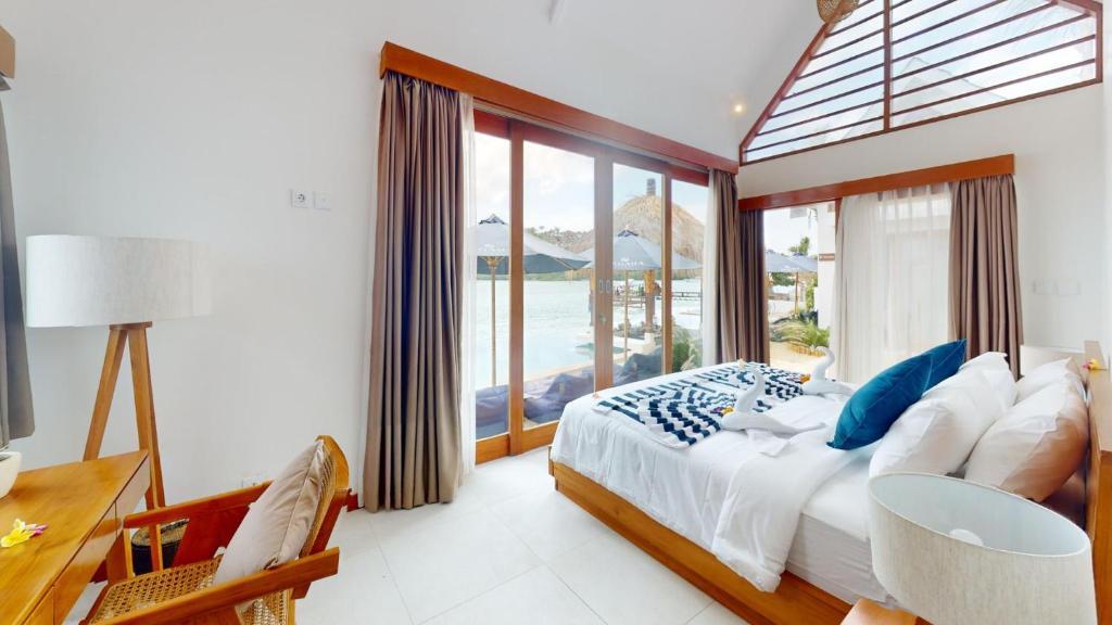 a bedroom with a bed and a large window at Segara Seaside Resort in Nusa Lembongan