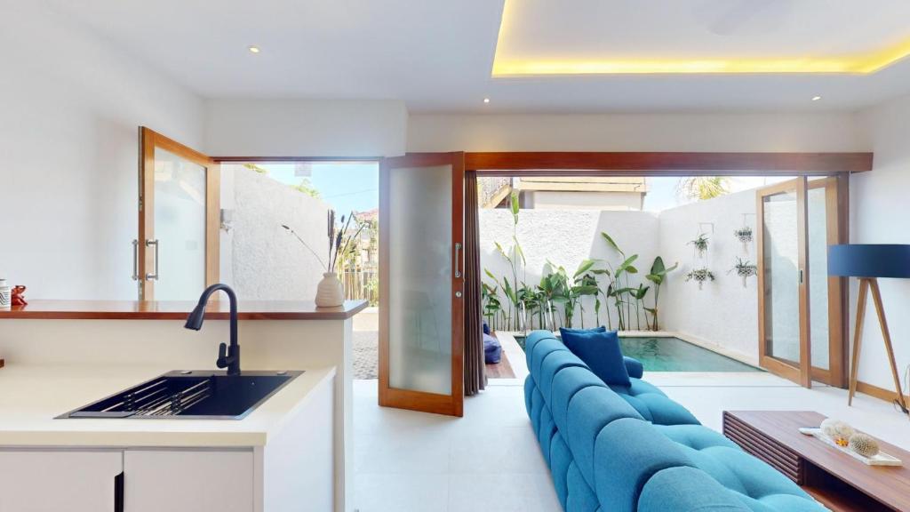 a kitchen and living room with a blue couch at Segara Seaside Resort in Nusa Lembongan