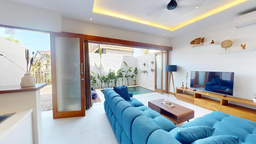 a living room with a blue couch and a television at Segara Seaside Resort in Nusa Lembongan