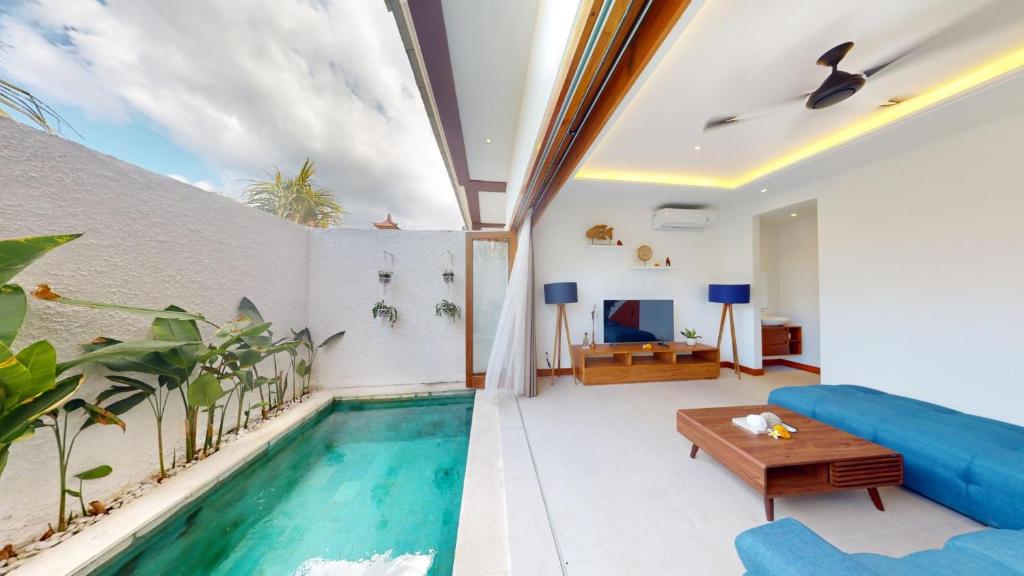a room with a swimming pool and a living room at Segara Seaside Resort in Nusa Lembongan