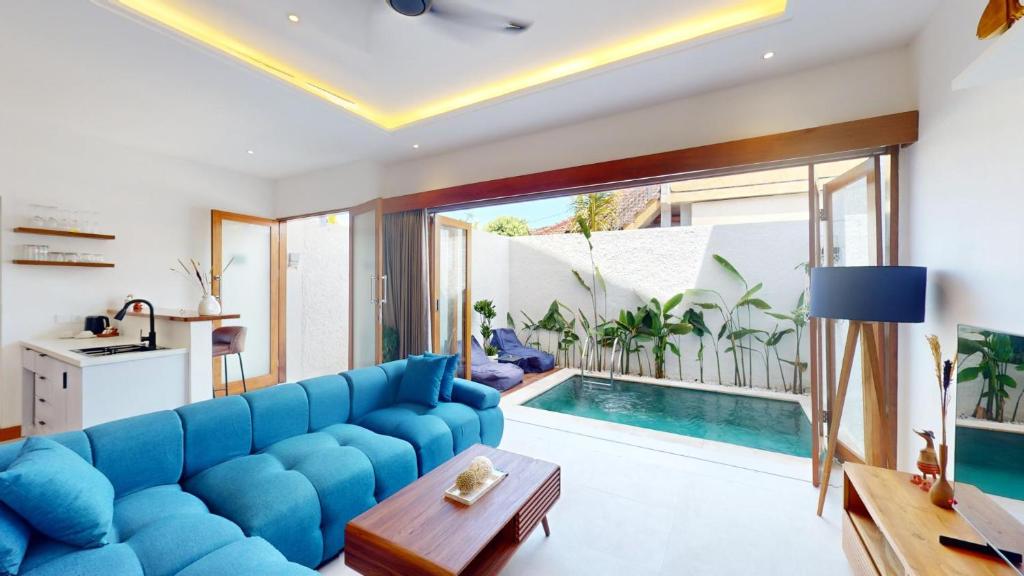 a living room with a blue couch and a swimming pool at Segara Seaside Resort in Nusa Lembongan