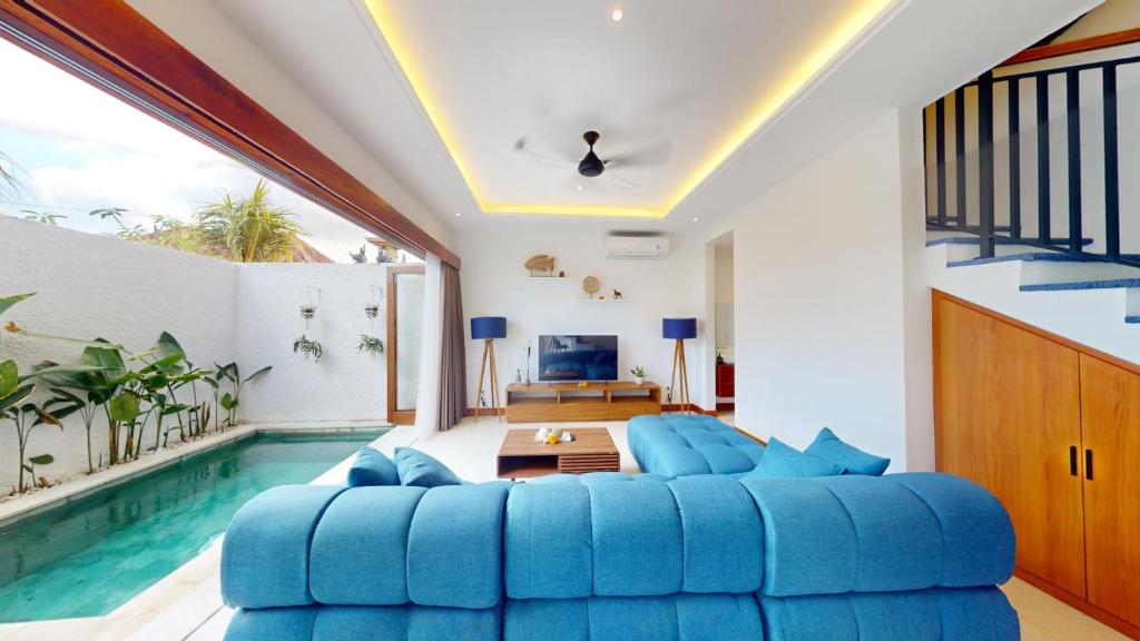 a living room with a blue couch and a swimming pool at Segara Seaside Resort in Nusa Lembongan