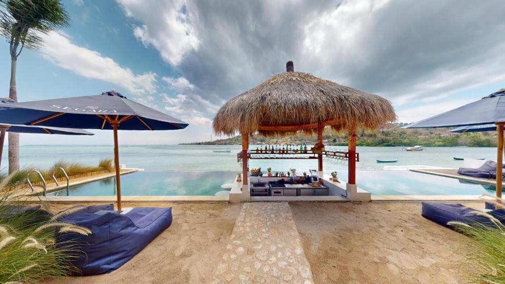 a bar on the beach next to the water at Segara Seaside Resort in Nusa Lembongan