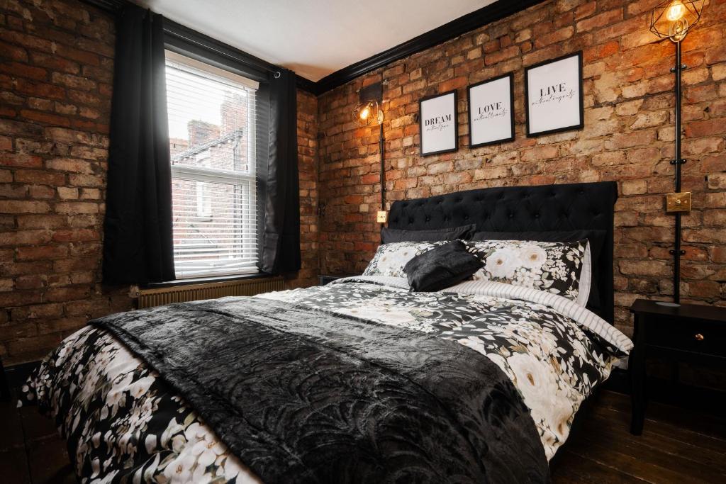 a bedroom with a brick wall and a bed at Swiss Haven - Spacious 3 Bedroom House in Liverpool