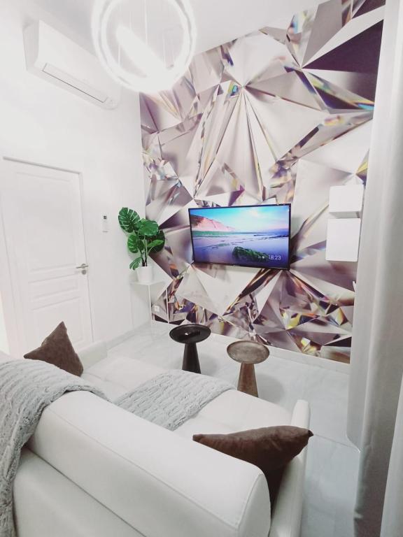 un salon avec un canapé blanc et une télévision dans l'établissement Studio le diamant, 3pers, 2 lits, wifi, à Agen