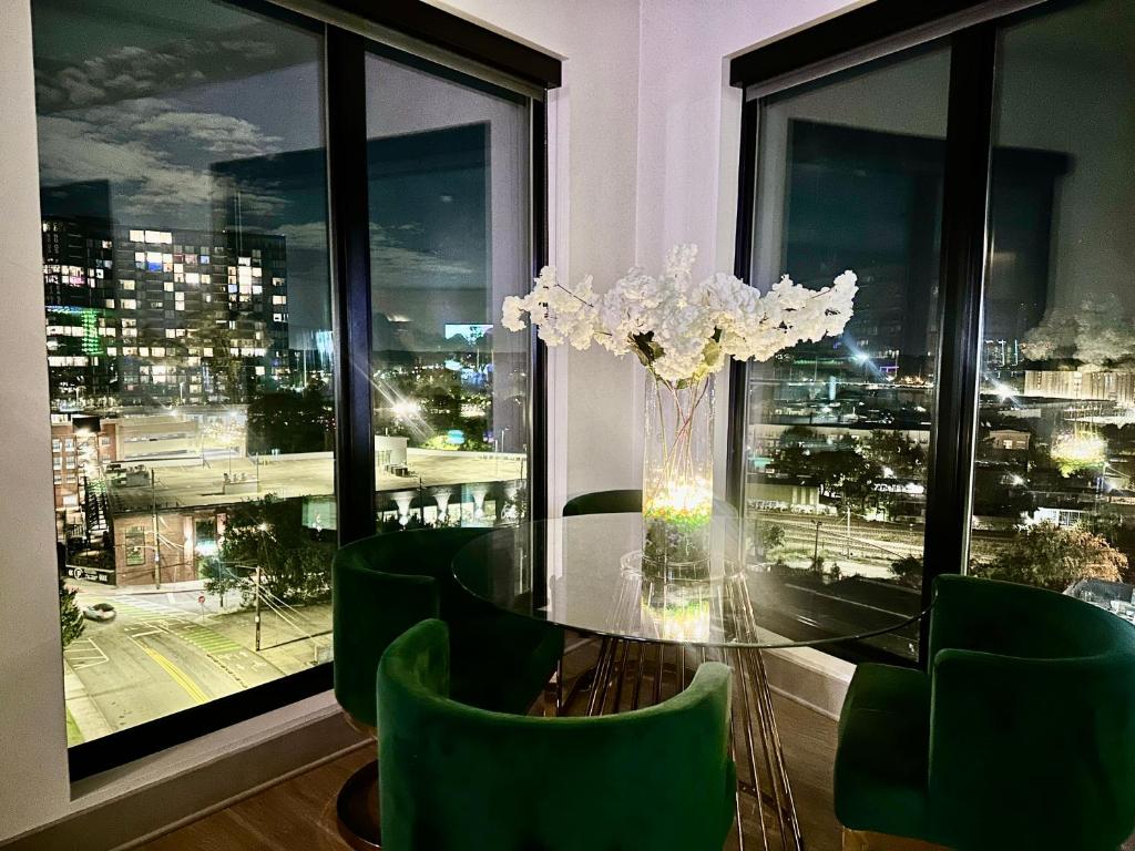 亚特兰大Modern luxury at the Interlock的一间设有玻璃桌和绿色椅子的用餐室
