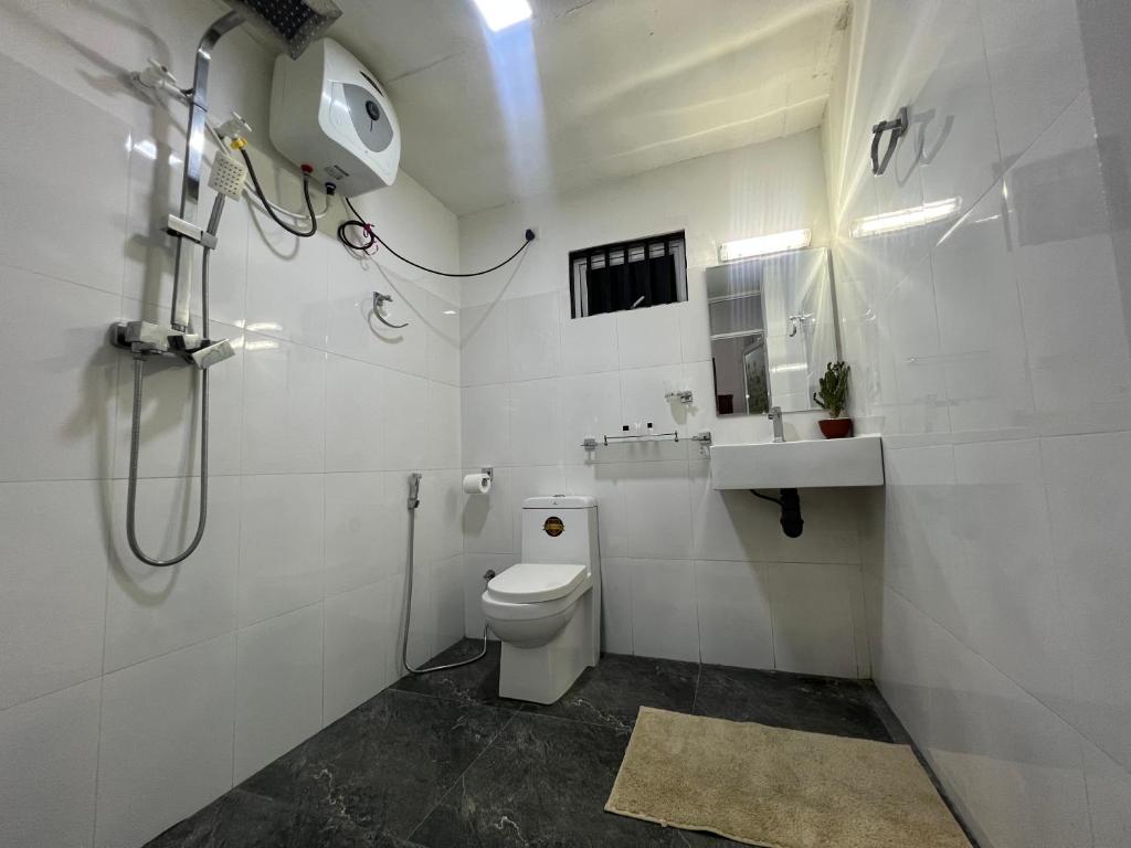 a white bathroom with a shower and a toilet at Cactus Boralesgamuwa in Boralesgamuwa