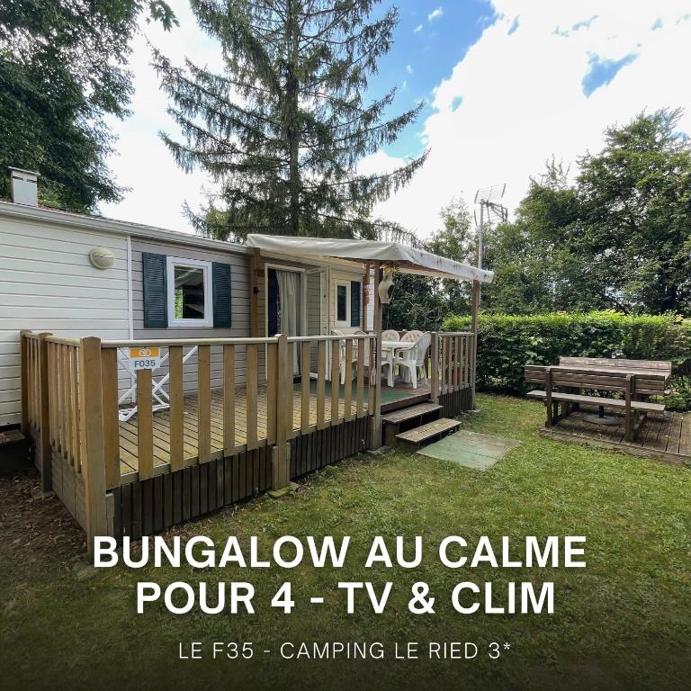 une petite maison avec une clôture et une table de pique-nique dans l'établissement Chez Roger - Bungalow climatisé avec TV - 2 chambres 4 personnes, à Boofzheim