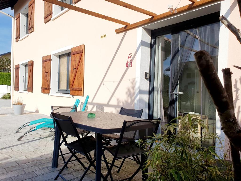 a wooden table and chairs on a patio at LA PIERRINA - Marmotte - Appart 3 étoiles in Aix-les-Bains