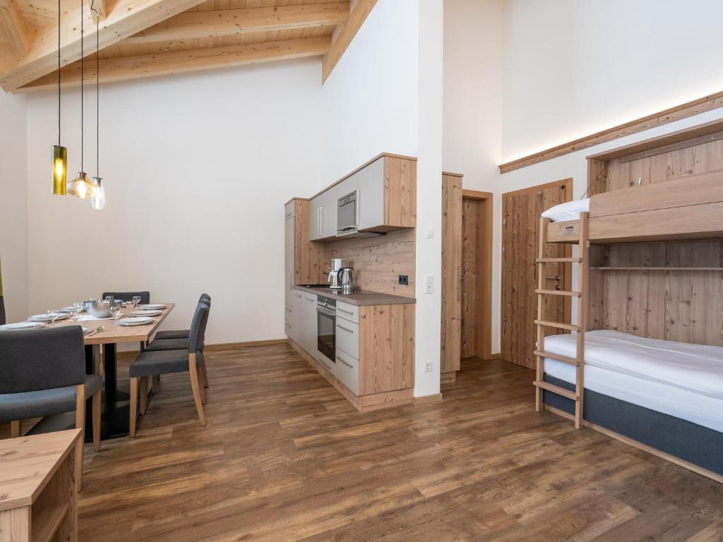 Pokój z łóżkiem piętrowym, stołem i krzesłami w obiekcie Luxury Chalet in Saalbach-Hinterglemm with Sauna w Saalbach Hinterglemm