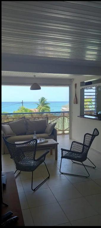 a living room with a couch and two chairs at L'appartement de la plage in Le Diamant