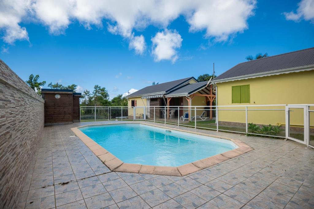 a swimming pool in the backyard of a house at Villa Cannelle - Maison climatisée St-François in Saint-François