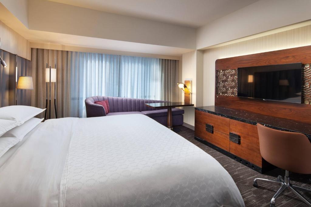 a hotel room with a bed and a flat screen tv at Sheraton Grand Los Angeles in Los Angeles