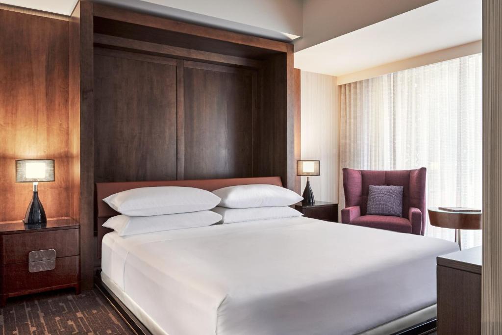 a bedroom with a large white bed and a chair at Sheraton Grand Los Angeles in Los Angeles