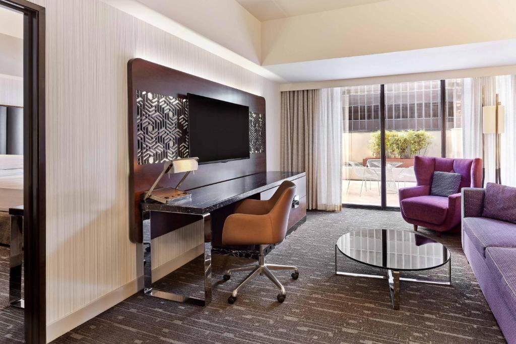 a hotel room with a desk and a bedroom at Sheraton Grand Los Angeles in Los Angeles