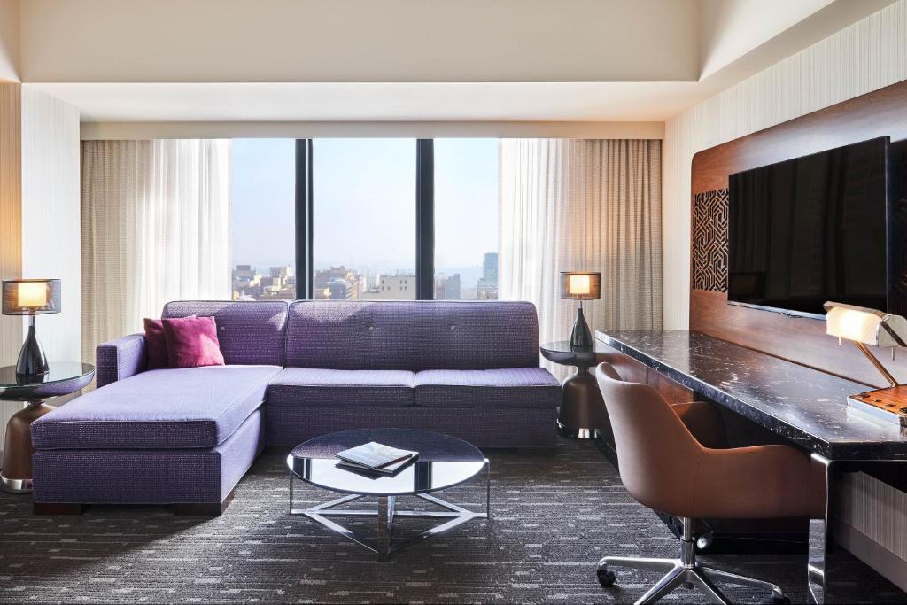 a living room with a couch and a tv at Sheraton Grand Los Angeles in Los Angeles