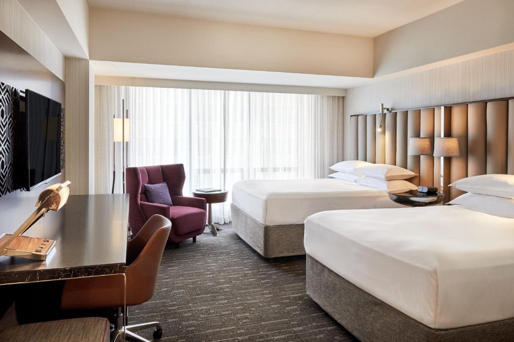 a hotel room with two beds and a desk at Sheraton Grand Los Angeles in Los Angeles