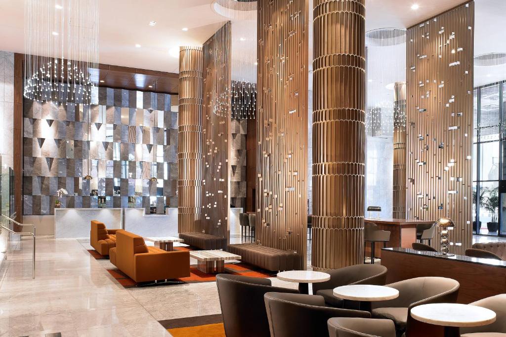 a lobby with tables and chairs and columns at Sheraton Grand Los Angeles in Los Angeles