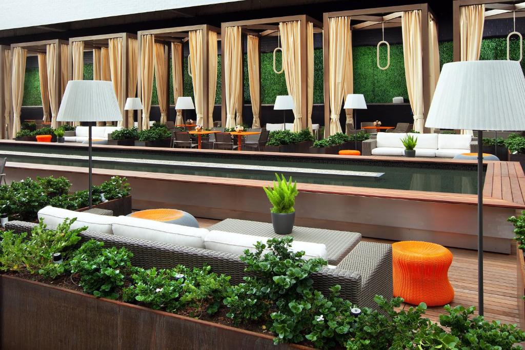 a lobby with white couches and tables and plants at Sheraton Grand Los Angeles in Los Angeles