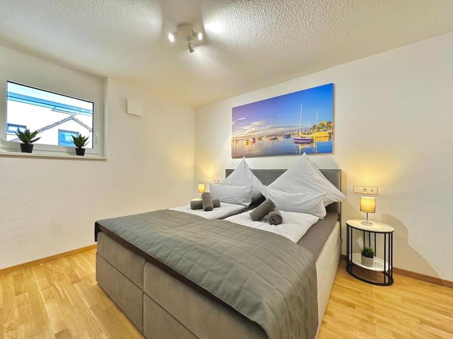 a bedroom with a large bed and two windows at Auszeit Apartment HAPPY in Friedrichshafen