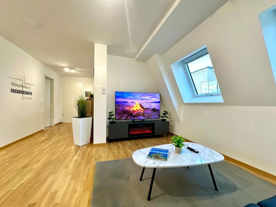 a living room with a tv and a table at Auszeit Apartment LAKELIFE in Friedrichshafen