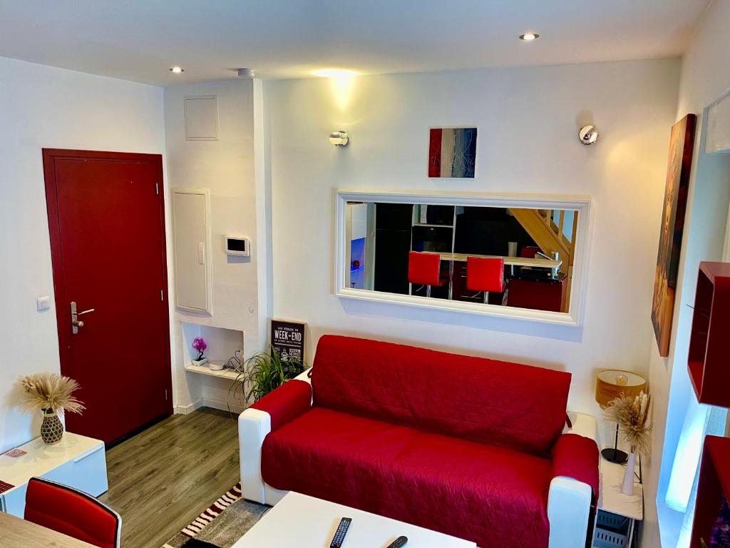 - un salon avec un canapé rouge et une fenêtre dans l'établissement Appartement en duplex proche gare d'Amiens, à Amiens