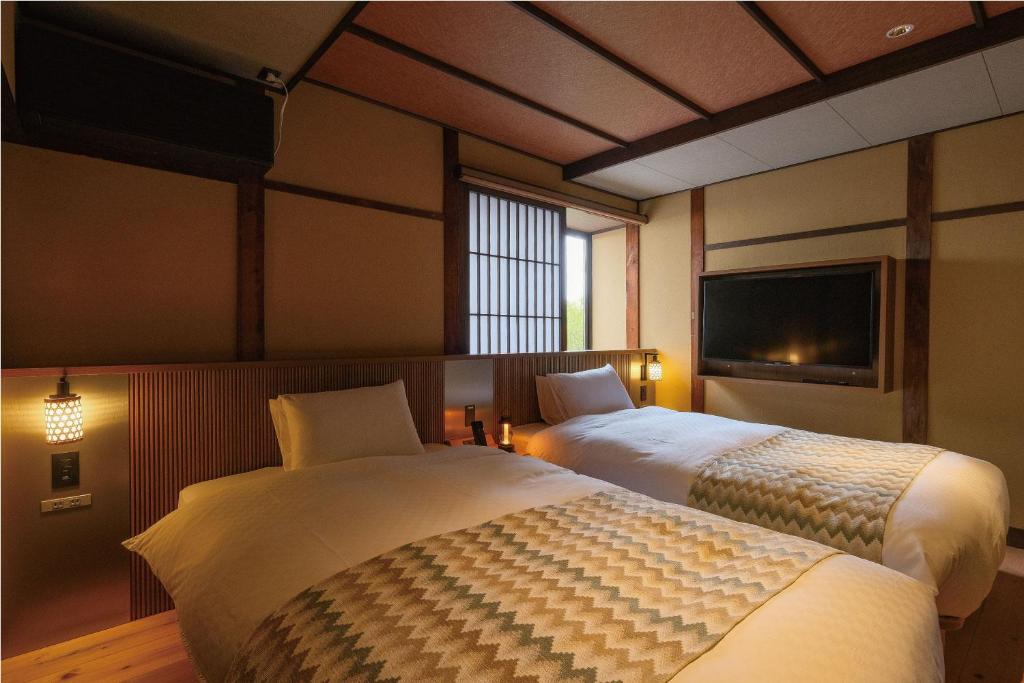 Postel nebo postele na pokoji v ubytování Tomonoura Shiomachi Hotel